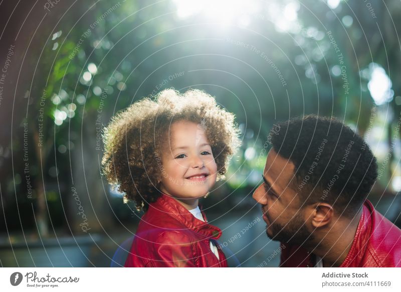 Glückliches kleines Mädchen umarmt Papa im Park Vater Tochter Umarmung Zusammensein Lächeln Straße Liebe ähnlich urban Kind Mann ethnisch wenig Partnerschaft