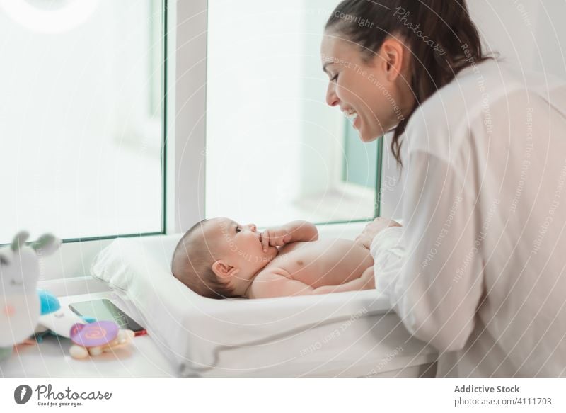 Zufriedene Mutter spielt mit liegendem Baby Lügen Lachen spielen Lächeln Zusammensein Liebe Kind Säugling bezaubernd unschuldig wenig niedlich Pflege heimwärts