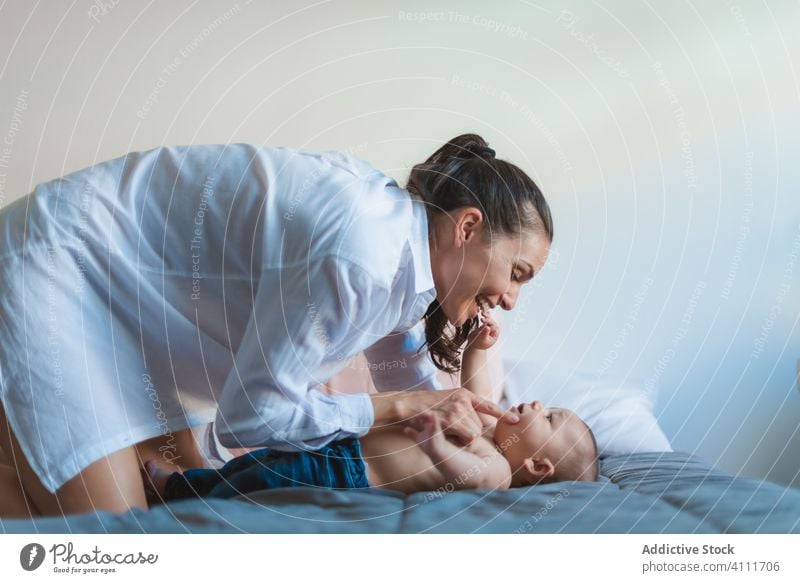 Überglückliche Mutter und glückliches kleines Baby im Bett Lügen Lächeln Lachen genießen spielen Zusammensein Liebe heimwärts Pflege Eltern Glück Kind Angebot