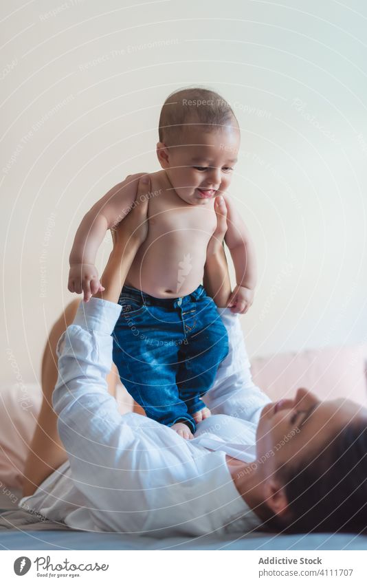 Glückliche gesichtslose Mutter spielt mit Baby im Schlafzimmer spielen Lächeln Lügen genießen Zusammensein Kind Eltern bezaubernd Liebe wenig Pflege unschuldig