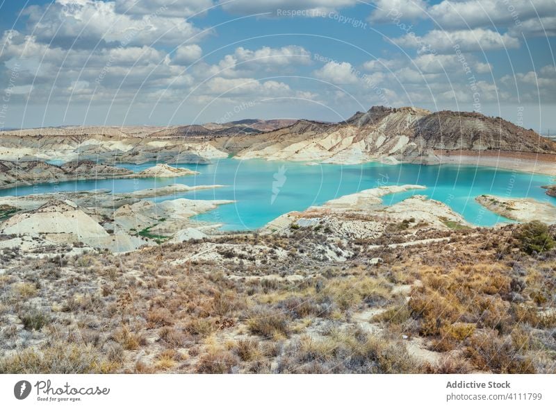 Sauberer See in Bergnähe und grasbewachsenes Ufer Berge u. Gebirge Gras trocknen wolkig Himmel algeciras Spanien murcia Stausee Teich Becken Küste niemand Kamm