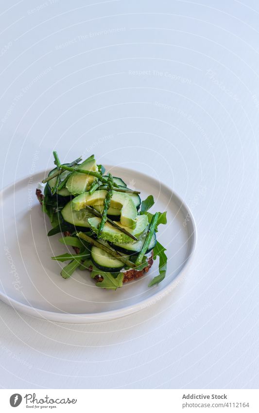 Leckeres Toastbrot mit frischem Gemüse und Kräutern auf dem Teller Zuprosten grün Gesundheit Vegetarier Avocado Salatgurke natürlich Kraut Lebensmittel Brot