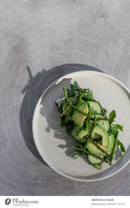 Leckeres Toastbrot mit frischem Gemüse und Kräutern auf dem Teller Zuprosten grün Gesundheit Vegetarier Avocado Salatgurke natürlich Kraut Lebensmittel Brot