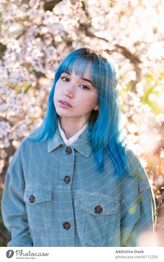 Trendige Frau im blühenden Garten Frühling Blütezeit Teenager gefärbtes Haar Blume Stil trendy modern jung blaue Haare Baum Natur geblümt schön Saison frisch