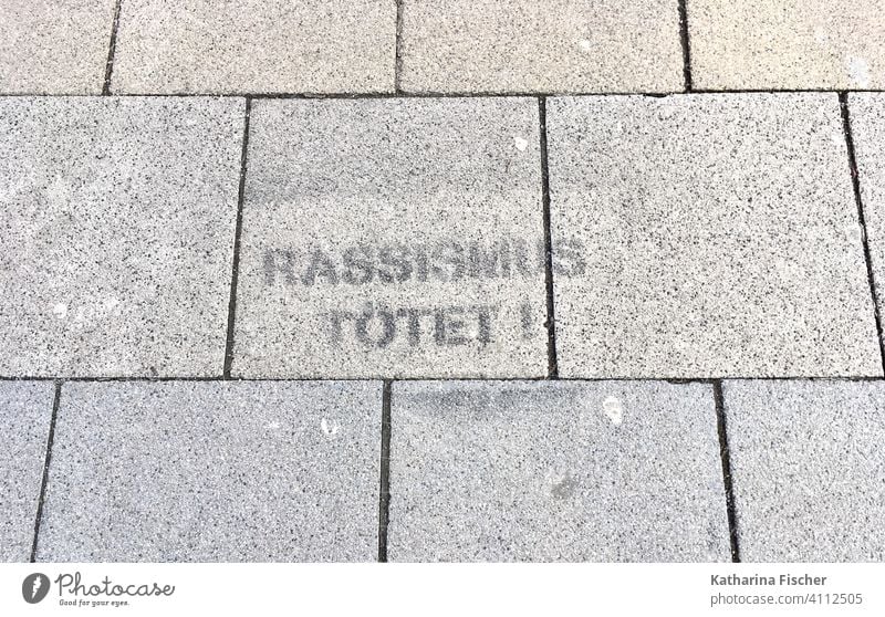 Rassismus tötet! Straße Asphalt Spruch Graffiti Schriftzeichen Außenaufnahme Menschenleer Tag Buchstaben Wort Mauer Typographie Text Aussage Geschichte Hass