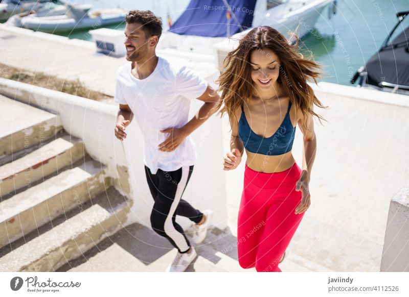 Sportliches Paar trainiert hart, indem es gemeinsam im Freien Treppen hochläuft. rennen Fitness Schritt Training Frau Mann Mädchen passen Aktivität jung