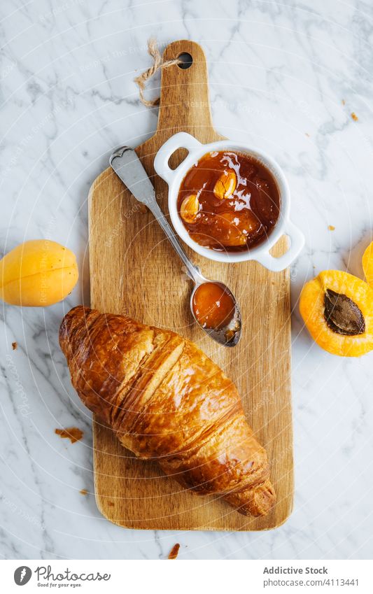 Croissant und Aprikosenmarmelade auf Holzbrett Marmelade Gebäck Frühstück backen frisch natürlich Morgen Lebensmittel dienen lecker geschmackvoll Mahlzeit