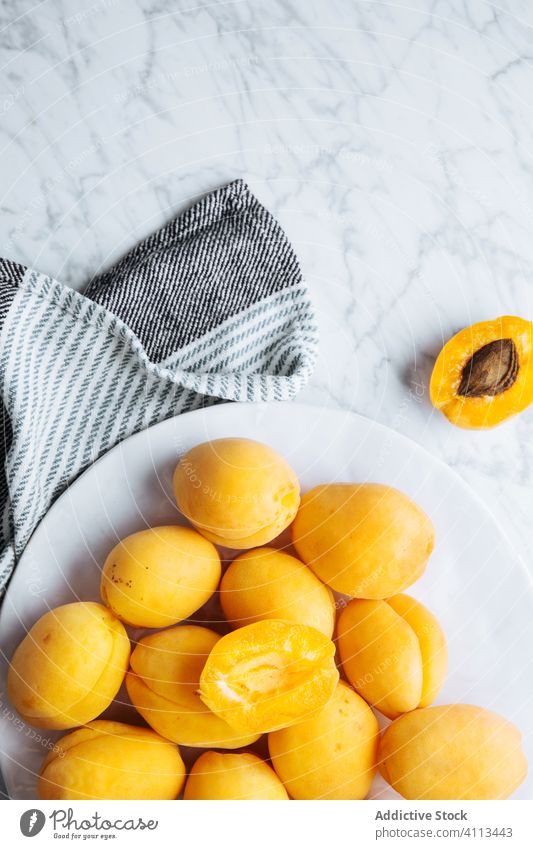 Teller mit frischen Aprikosen auf weißem Marmortisch Frucht reif Tisch gelb orange natürlich Lebensmittel lecker geschmackvoll Gesundheit organisch Bestandteil