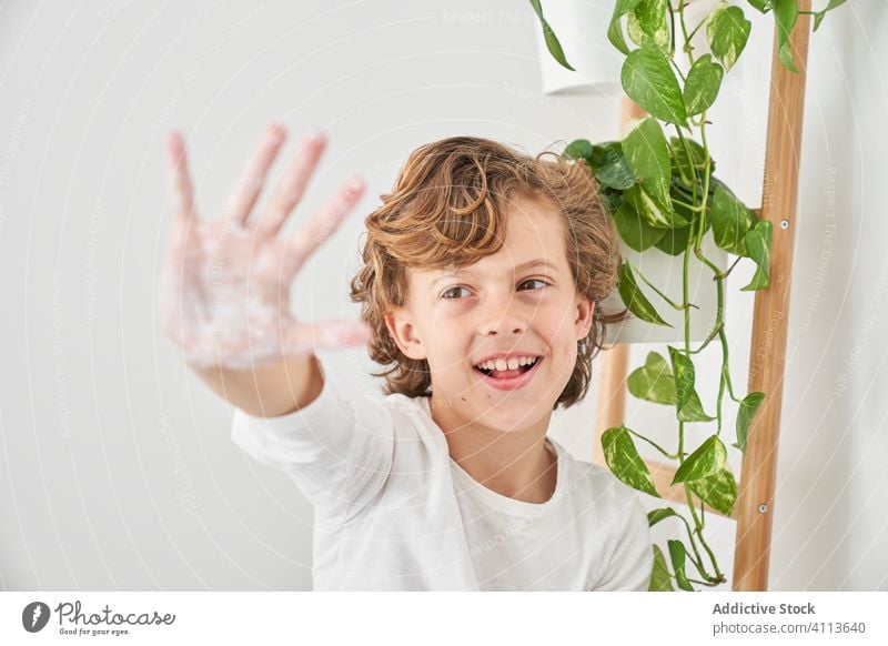 Blondes Kind wäscht sich die Hände in der Küchenspüle, um eine Infektion zu vermeiden Waschbecken Lifestyle Wäsche waschen im Innenbereich Sohn Junge Wasser