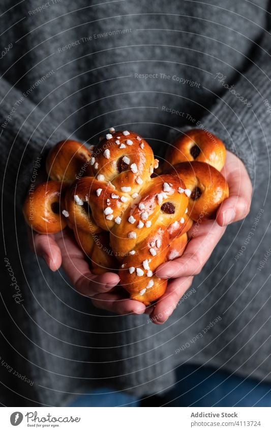 Frau hält köstliche hausgemachte Brötchen Lebensmittel backen selbstgemacht Hand geschmackvoll Gebäck süß Safran Tradition lecker frisch Ernährung appetitlich