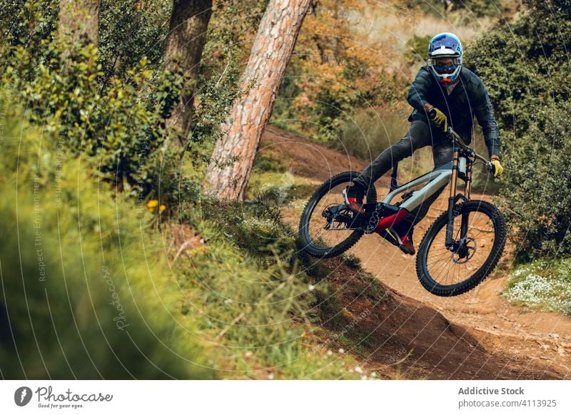 Downhill-Fahrer springt mit dem Fahrrad bergab und macht einen Peitschentrick Mountainbiking Radfahren Nachlauf Natur mtb Reiter Gerät Geschwindigkeit Zyklus