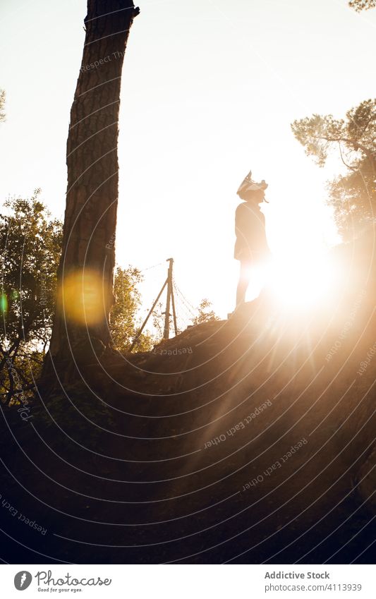 Downhill-MTB-Fahrer bei Sonnenuntergang mit Helm im Wald Fahrrad Schutzhelm Berge u. Gebirge Top Sport Gerät Abenteuer Hügel Sicherheit Aktivität mtb extrem