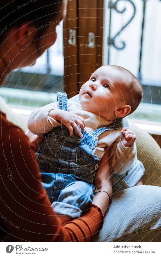 Mutter mit Baby sitzt am Fenster Babysprache sitzen Stuhl heimwärts gemütlich Komfort lässig Glück niedlich Liebe Angebot Frau Säugling bezaubernd Barfuß Kind