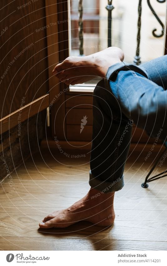 Person, die sich am Fenster ausruht ruhen heimwärts gemütlich Barfuß Jeanshose Windstille Wochenende Raum Stock sitzen Morgen Appartement flach räkeln heimisch