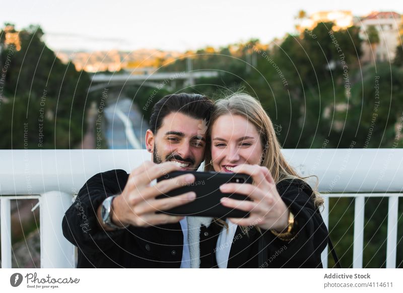 Glückliches multiethnisches Paar macht Selfie in der Stadt Smartphone Großstadt Zusammensein Brücke jung Straße urban Lifestyle Gerät Apparatur Mobile