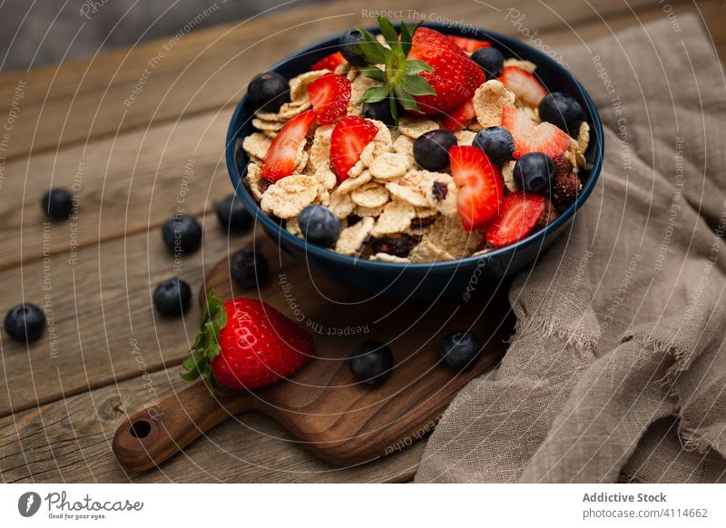 Frische Cornflakes mit Erdbeeren und Blaubeeren auf dem Holztisch Frühstück Müsli lecker Tisch frisch Schalen & Schüsseln organisch Gesundheit Ernährung Beeren