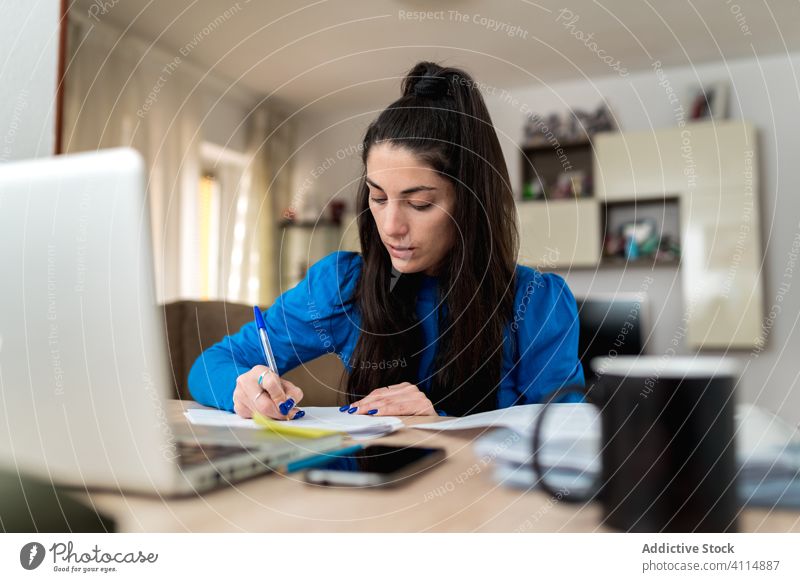 Weibliche Freiberuflerin, die zu Hause arbeitet Frau freiberuflich heimwärts schreiben Hinweis Papier Fokus Arbeit Projekt abgelegen Laptop Tisch Job gemütlich