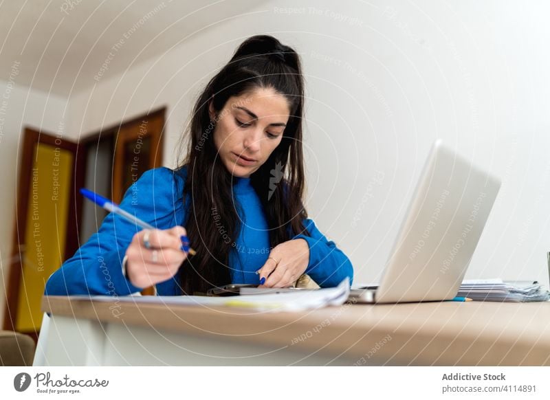 Weibliche Freiberuflerin, die zu Hause arbeitet Frau freiberuflich heimwärts schreiben Hinweis Papier Fokus Arbeit Projekt abgelegen Laptop Tisch Job gemütlich