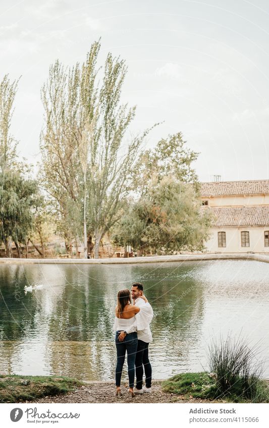 Paar in der Nähe von Teich im Garten Termin & Datum Liebe Händchenhalten Ufer Windstille romantisch Zusammensein Mann Frau Partnerschaft Zuneigung See Wasser