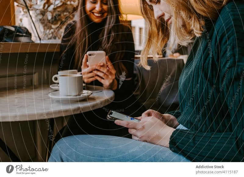 Freundinnen ruhen sich in gemütlichem Cafe aus Frauen Café Lachen Zusammensein Kaffee Smartphone benutzend Witz lässig Wochenende jung Sitzung Restaurant