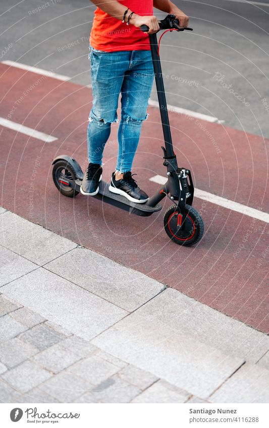 Junger Junge Reiten Elektro-Roller gesichtslos Afro-Look jung Mann schwarz Afroamerikaner urban Seitenansicht Elektroroller außerhalb Tretroller