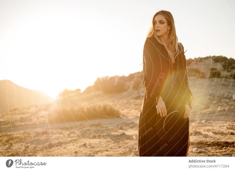 Stilvolle Frau steht auf Fels in der Landschaft Stein Sonnenuntergang Hut Spaziergang Outfit Schleim Model schwarz trendy Natur Felsen Felsbrocken Abend