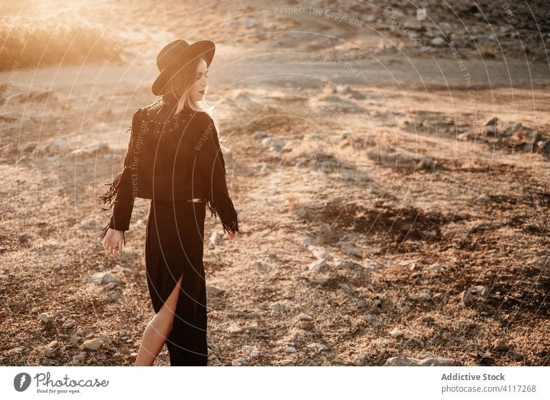 Stilvolle Frau steht auf Fels in der Landschaft Stein Sonnenuntergang Hut Spaziergang Outfit Schleim Model schwarz trendy Natur Felsen Felsbrocken Abend