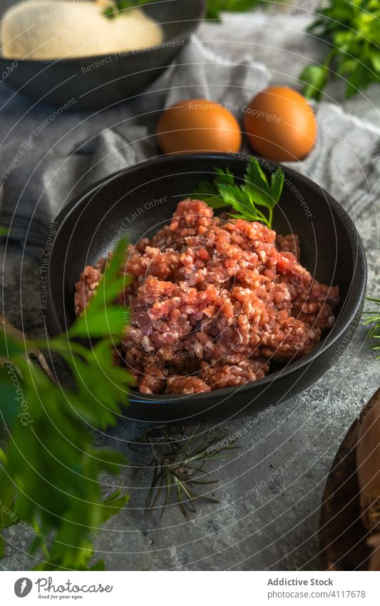 Schüssel mit Hackfleisch neben Eiern und Kräutern Fleisch zerkleinern Kraut Küche Koch Bestandteil frisch rustikal Mahlzeit Lebensmittel Feinschmecker Ernährung