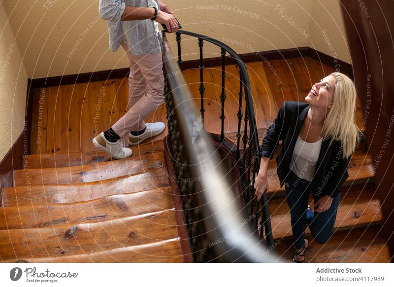 Junges Paar geht die Treppe hinunter Treppenhaus Spaziergang heimwärts Zusammensein Lächeln Kommunizieren Mann Frau jung Freund Freundin sprechen heiter reden