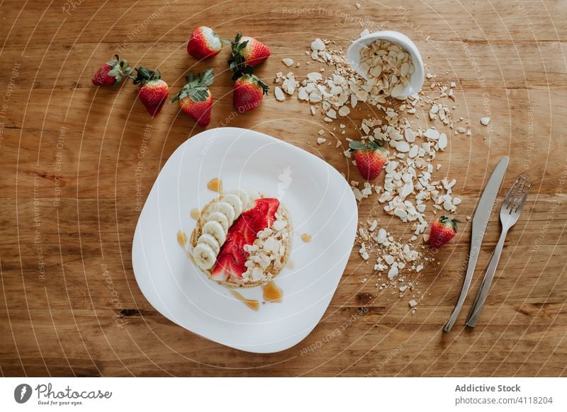 Pfannkuchen mit Banane und Erdbeeren mit Heidelbeeren und Kokosnuss dekoriert Frühstück süß dienen Tisch Blaubeeren Schuppen Diät Teller Stapel geschmackvoll