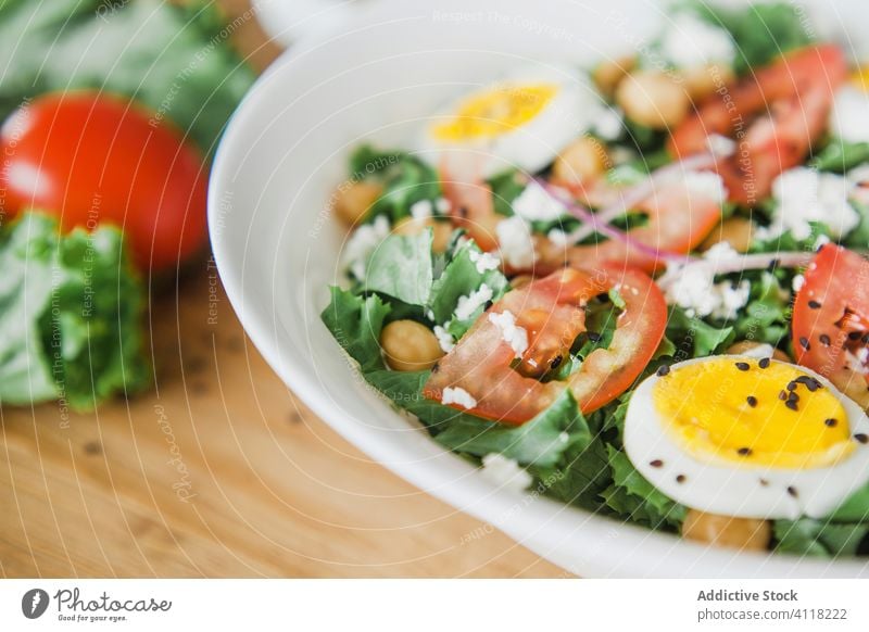 Gemüsesalat mit Kichererbsen und Eiern Salatbeilage Gesundheit Speise Silberwaren Saucen Tomate Schalen & Schüsseln gekocht Holz Tisch Lebensmittel Mahlzeit