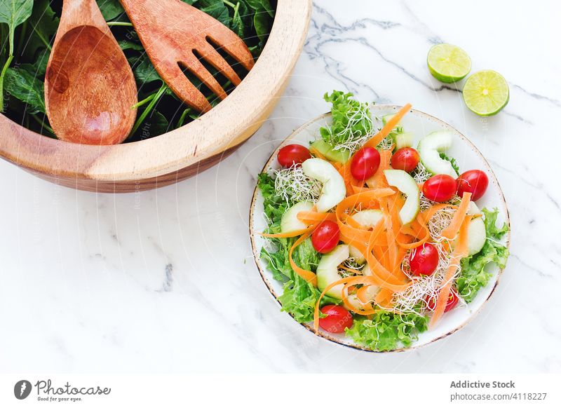 Gesunder Gemüsesalat mit Apfel und Kirschtomaten Salatbeilage gesunde Ernährung grün Möhre Tomate Mikro-Grün Speise Abendessen Diät Kalk Zitrusfrüchte Teller