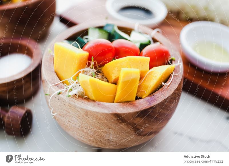 Salatschüsseln mit Microgreens und gehacktem Gemüse Salatbeilage gesunde Ernährung roh Zucchini Kürbis Mikrogrün Tomate Kirsche Holzplatte Salz balsamisch Erdöl