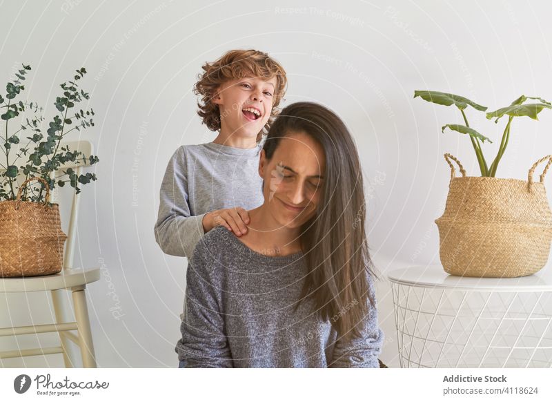 Glückliches Kind mit Mutter beim Spielen zu Hause heiter heimwärts Zusammensein Spaß haben Lachen spielerisch genießen Partnerschaft gemütlich Frau Junge Sohn