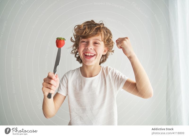 Glücklicher Junge mit Erdbeere auf Messer Erdbeeren spielen heimwärts Sommer Lächeln frisch Spaß Kind Lebensmittel Frucht Beeren Lachen reif führen süß Kindheit