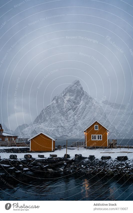 Malerische Landschaft mit Stadt am Seeufer unter grauem Himmel im Winter Hafengebiet Haus Wasser Township Dorf Ufer malerisch idyllisch ruhig Küste lofoten