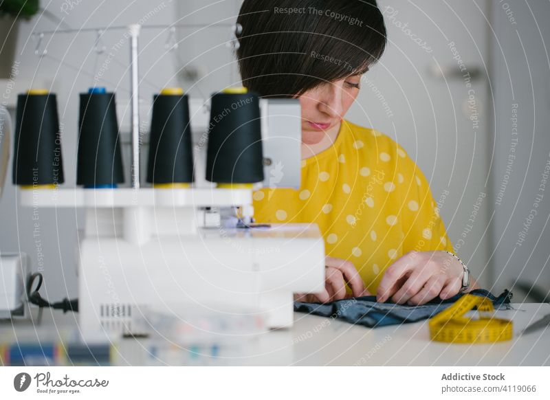 Näherin arbeitet zu Hause Frau nähen Nähmaschine heimwärts Werkstatt Jeansstoff Kleidungsstück Arbeit Erwachsener Prozess Schneider Kunstgewerbler