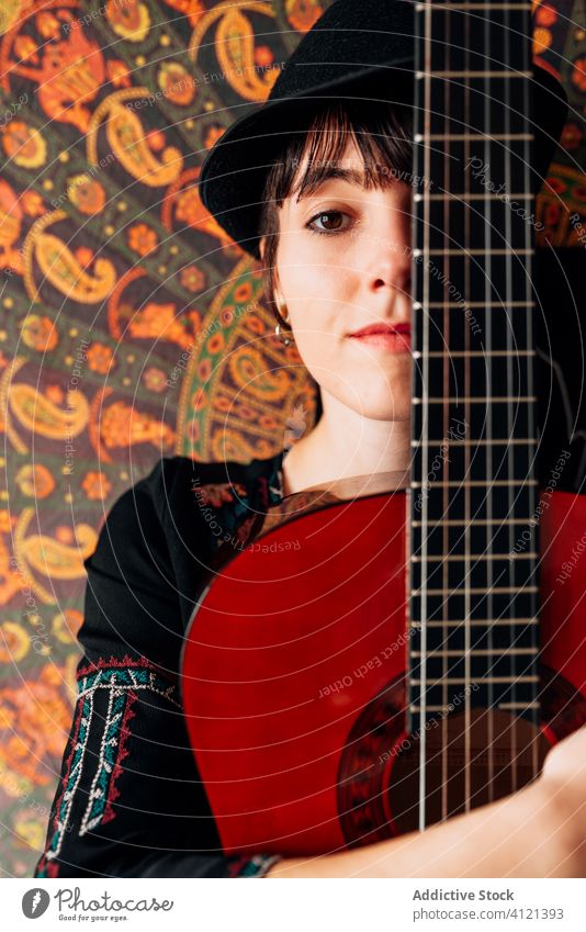 Zufriedene Frau umarmt die Gitarre akustisch Hipster Umarmung ruhen heimwärts Inhalt Wochenende Gitarrenspieler Freude Gelassenheit trendy Lächeln froh