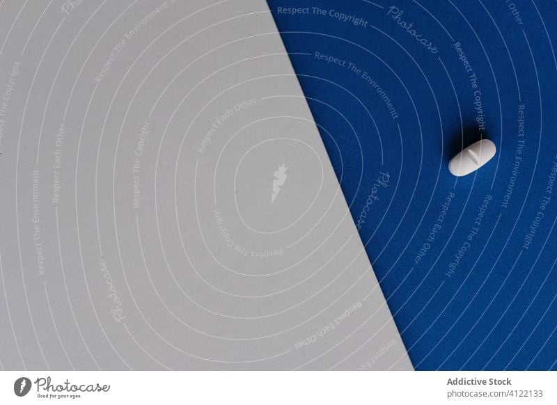 Weiße ovale Pille auf grauem und blauem Tisch Tablette Leckerbissen Verschreibung Medizin Medikament sehr wenige Grippe Oval Krankheit medizinisch krank