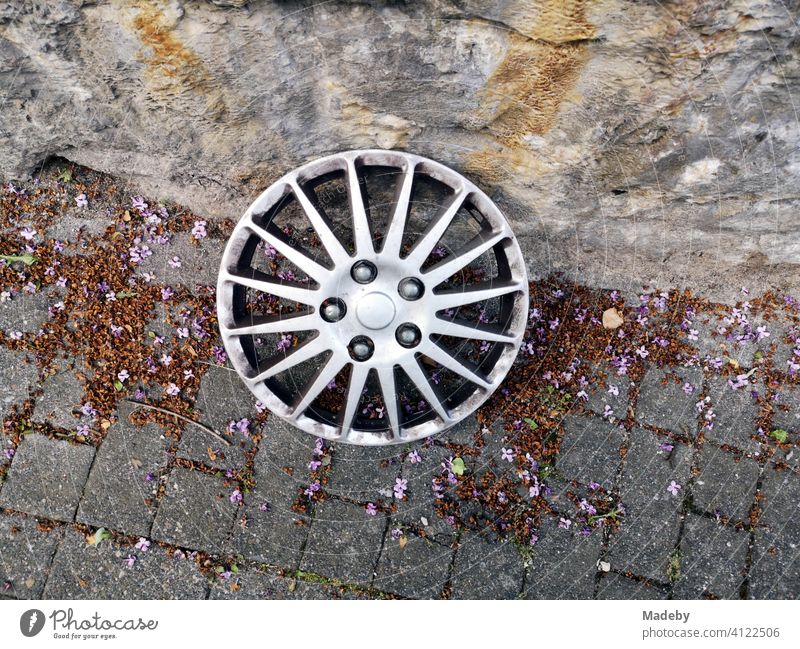 Radkappe mit sternförmigem Design im Stil einer Leichmetallfelge im Herbst am Straßenrand in der Altstadt von Oerlinghausen bei Bielefeld am Hermannsweg im Teutoburger Wald in Ostwestfalen-Lippe