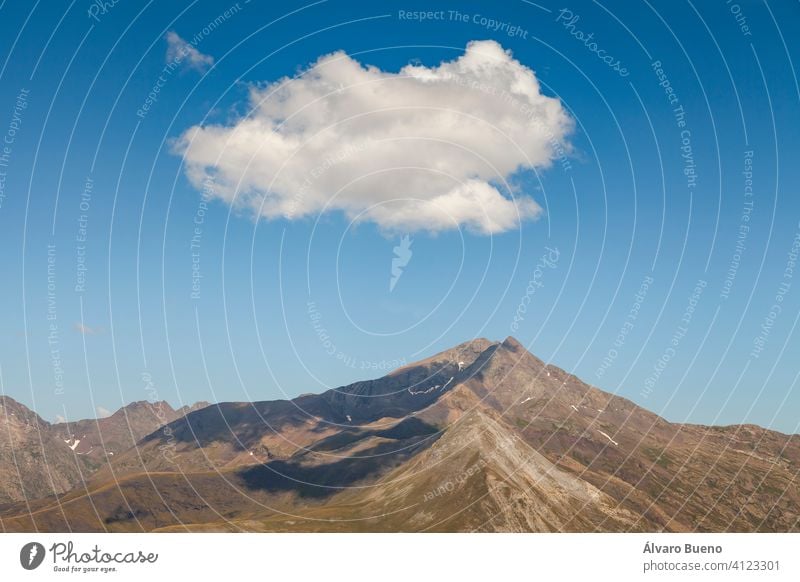 Landschaftsfotografie von steilen Bergen im Sommer, einsamen Wolken und stillen Hochweiden, in den aragonesischen Pyrenäen, Provinz Huesca, im Gebiet des Naturparks Posets-Maladeta.