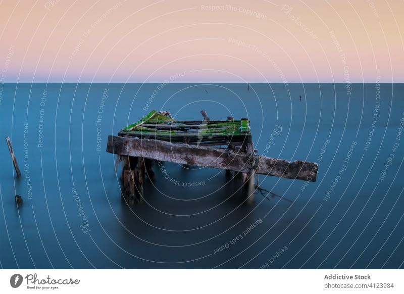 Alte hölzerne Seebrücke in ruhiger See MEER Pier alt schäbig Windstille Sonnenuntergang Landschaft Abend Wasser Konstruktion Verlassen Himmel Natur Küste Meer