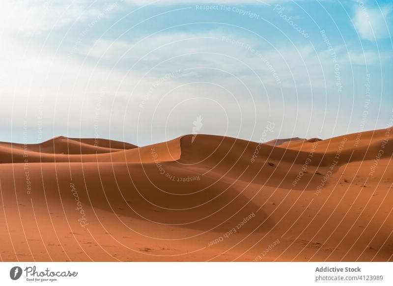 Sandige Wüstendünen unter blauem Himmel wüst Düne Landschaft sehr wenige Natur heiß wolkig sonnig trocknen trocken Gelände reisen Tourismus leer erwärmen wild