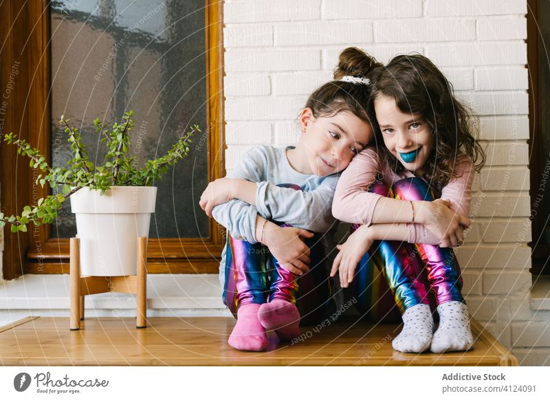 Fröhliche kleine Mädchen essen blaue Kaubonbons Kauen Bonbon Leckerbissen süß teilen heimwärts Spaß Glück Kinder geschmackvoll Lachen lecker Schwester Pyjama