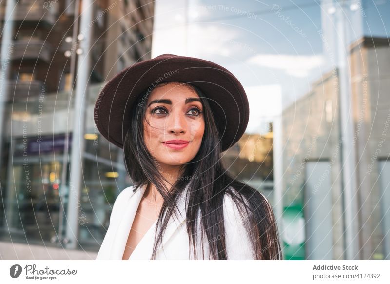 Glückliche junge Frau in trendigem Outfit Stil trendy Mode Straße Himmel Frühling heiter Saison Hut positiv Wind modern sonnig urban Freude froh genießen