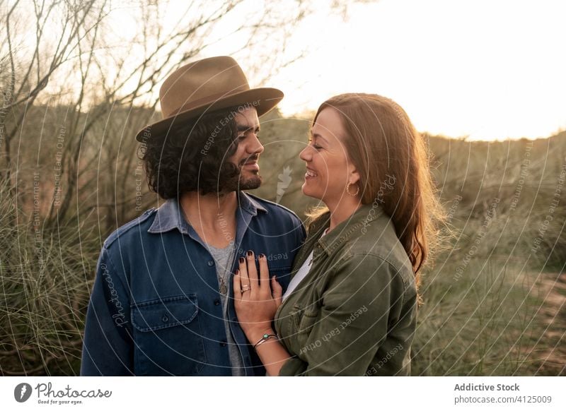 Glückliches Paar umarmt sich auf dem Land Umarmung Landschaft Abend Termin & Datum Liebe Buchse Angebot Sonnenuntergang Mann Frau heiter romantisch Lifestyle