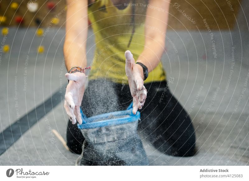 Crop-Frau bereitet sich mit Talkum an den Händen auf das Training vor Sport Kraft rutschfest vorbereiten sitzen Hand Athlet anstrengen Gerät Fitnessstudio