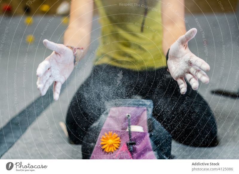 Crop-Frau bereitet sich mit Talkum an den Händen auf das Training vor Sport Kraft rutschfest vorbereiten sitzen Hand Athlet anstrengen Gerät Fitnessstudio