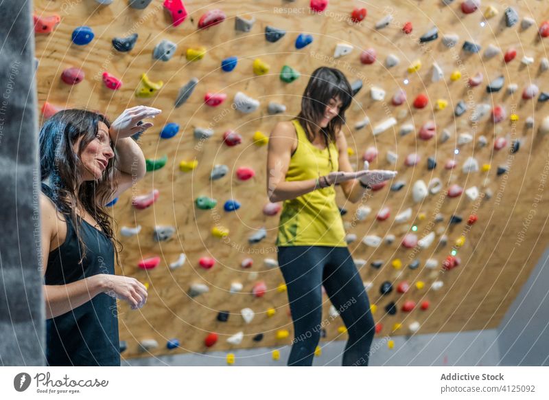 Fröhliche Kletterin genießt das Training im Fitnessstudio Frauen Aufsteiger ruhen Pause Wand Aufstieg Sport Lächeln Sportlerin Felsbrocken Hobby Lachen Glück