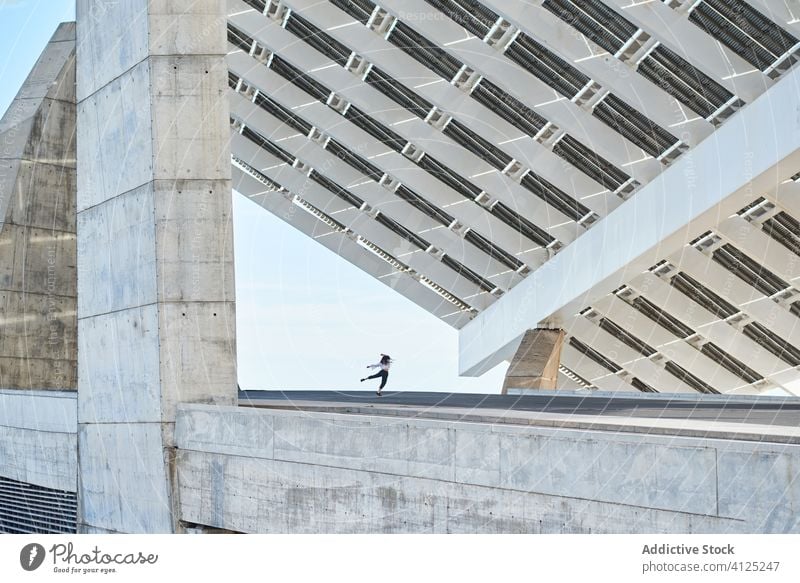 Unbekannte Person tanzt auf modernem Gebäude Tänzer Ballerina springen Zeitgenosse extrem Konzept hoch Beton urban Fliege Konstruktion Straße Bewegung